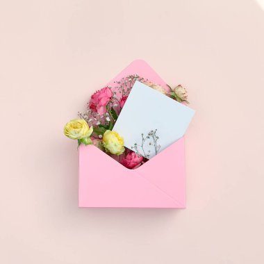 Pastel arka planda pembe çiçek hediyesi. Çiçekli yaz ya da ilkbahar güllü açık kutu. Beyaz kart maketi. Doğum günü, düğün, sevgililer günü ya da anneler günü konsepti