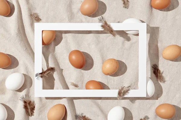 Easter background with yellow and white natural eggs. Happy easter spring layout with sunshine and harsh shadow. Spring, retro, hunt, rustic concept