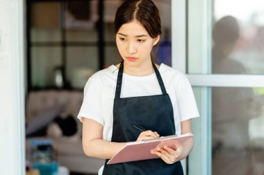 Asyalı garson misafirler gittikten sonra otel odasını kontrol ediyor.