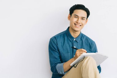 Asyalı işadamı evinde oturmuş roman yazıyor.