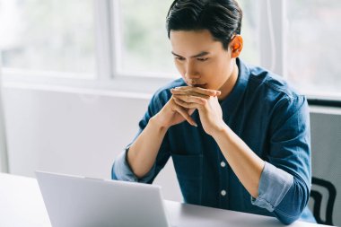 Asyalı adam bilgisayar ekranına yoğunlaşıyordu.