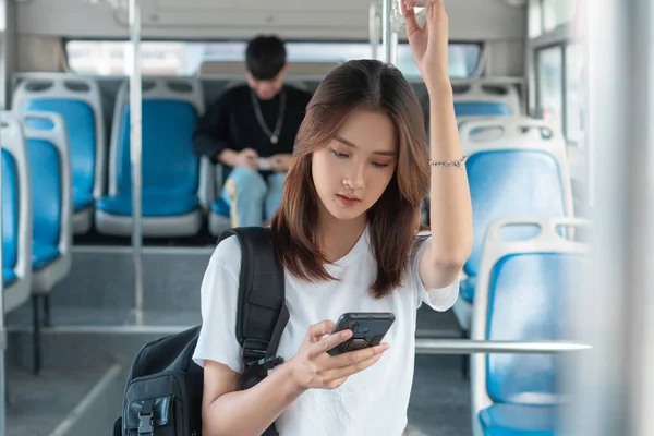 Asian woman using smartphone on bus
