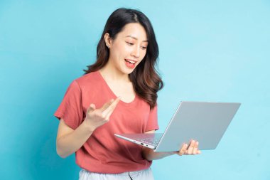 Güzel Asyalı kadın arkadaşlarıyla video görüşmesi yapmak için dizüstü bilgisayar kullanıyor.