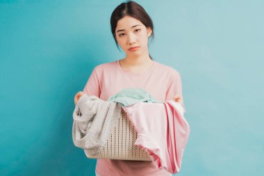 Elbise sepetini tutan genç kız.