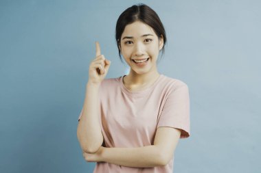 Mavi arka planda bir fikir düşünen bir kızın portresi.