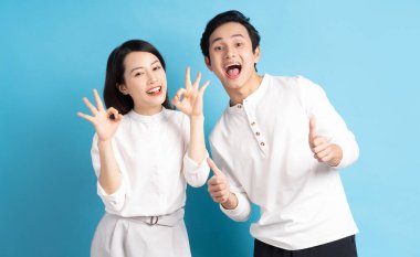 Mavi arka planda duran genç bir çiftin portresi