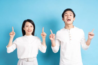 Mavi arka planda duran genç bir çiftin portresi