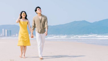 Genç Asyalı çift sahilde yaz tatilinin tadını çıkarıyor.