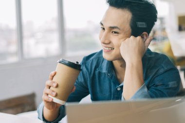 Asyalı adam cam kapıda çalışıyor.