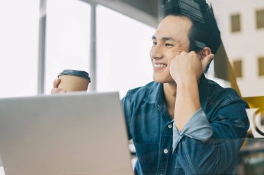 Asyalı adam cam kapıda çalışıyor.