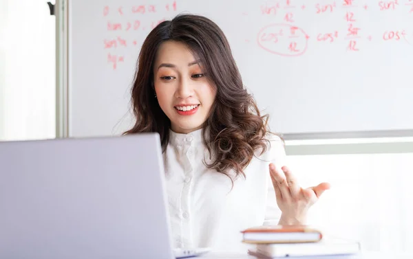 Asian female teacher teaching online at home