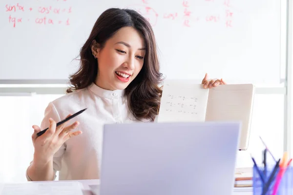Asian female teacher teaching online at home