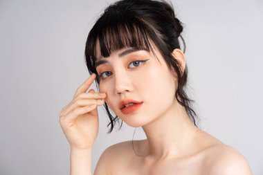 Güzel ciltli ve gülümseyen Asyalı bir kadının portresi.