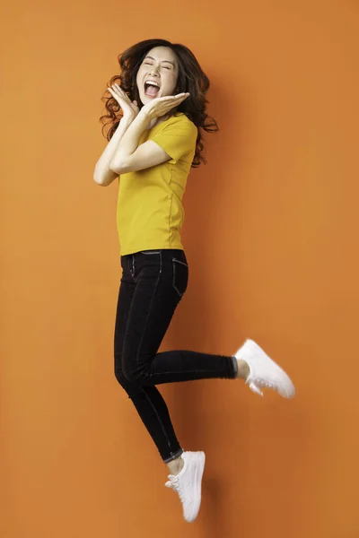 Giovane Ragazza Asiatica Saltando Sfondo Arancione — Foto Stock