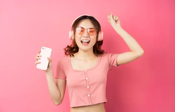 Ung Asiatisk Flicka Bär Hörlurar Och Använda Telefonen Rosa Bakgrund — Stockfoto