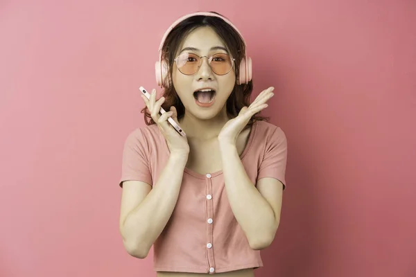 Joven Chica Asiática Con Auriculares Uso Del Teléfono Sobre Fondo — Foto de Stock