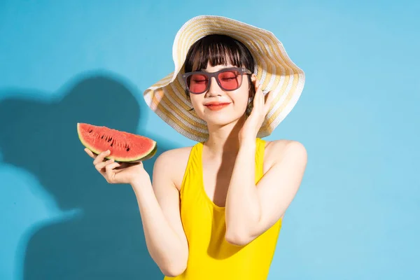 Hermosa Mujer Asiática Vistiendo Mono Amarillo Sobre Fondo Azul Comiendo — Foto de Stock