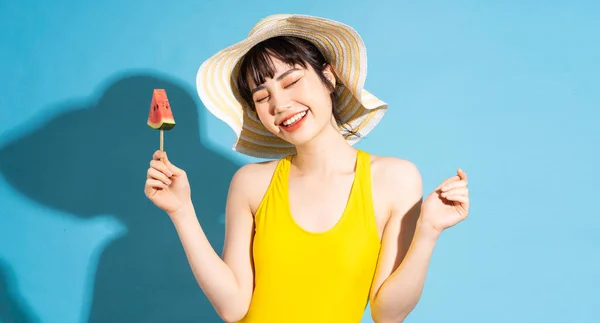 Mulher Asiática Bonita Vestindo Macacão Amarelo Fundo Azul Comendo Frutas — Fotografia de Stock