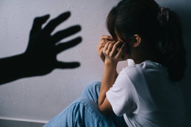 Asyalı kadın erkek arkadaşının şiddeti yüzünden yüzüne sarılıp ağlıyor.