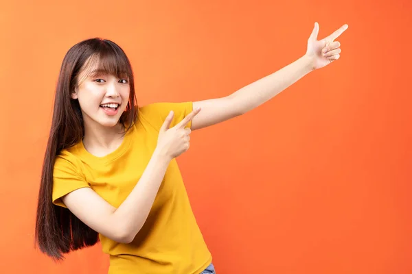 Afbeelding Van Jonge Aziatische Vrouw Met Geel Shirt Oranje Achtergrond — Stockfoto