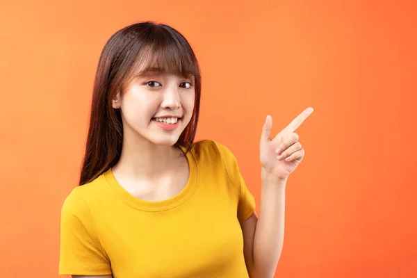 주황색 배경에 티셔츠를 아시아 소녀의 — 스톡 사진