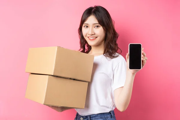Woman holding phone and cargo box laughing happily on background