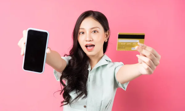 Joven Asiática Sosteniendo Teléfono Móvil Mientras Sostiene Una Tarjeta Bancaria — Foto de Stock
