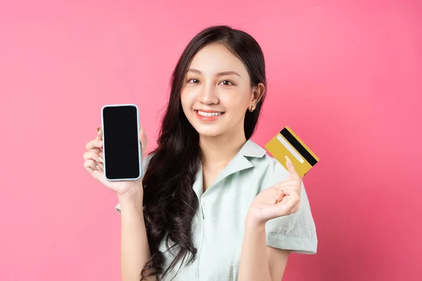 Joven Asiática Sosteniendo Teléfono Móvil Mientras Sostiene Una Tarjeta Bancaria — Foto de Stock