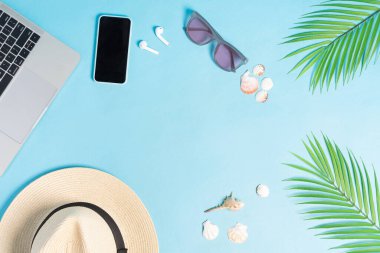 Mavi arka plandaki plaj aksesuarlarının en üst görüntüsü.