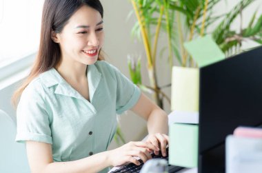 Genç Asyalı iş kadını heyecanla çalışıyor.