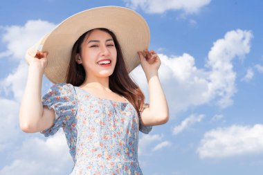 Gökyüzünde poz veren genç Asyalı kadın