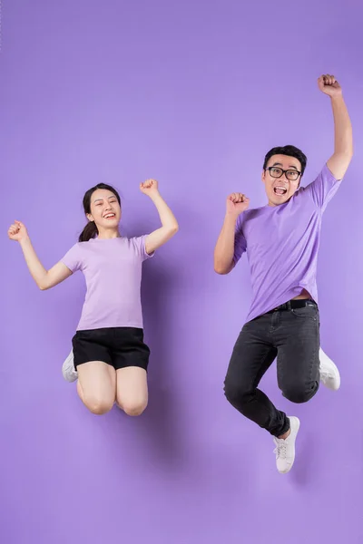 Jong Aziatisch Paar Springen Paars Achtergrond — Stockfoto