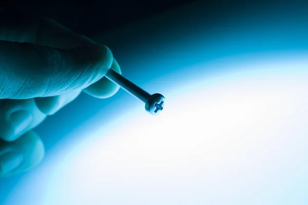 Schraube Der Hand Auf Blauem Hintergrund — Stockfoto