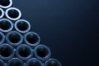 screw-nuts on a dark surface