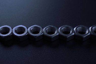 screw-nuts on a dark surface