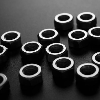 screw-nuts on a dark surface