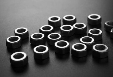 screw-nuts on a dark surface