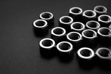 screw-nuts on a dark surface