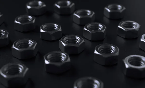 screw-nuts on a dark surface