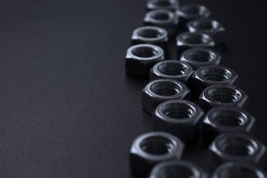 screw-nuts on a dark surface