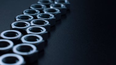 screw-nuts on a dark surface