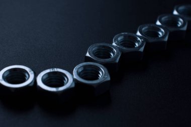 screw-nuts on a dark surface