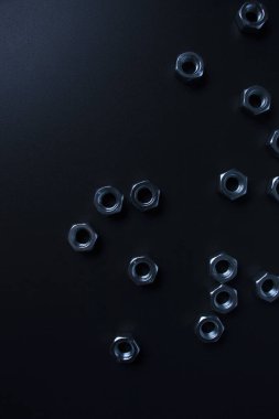 screw-nuts on a dark surface