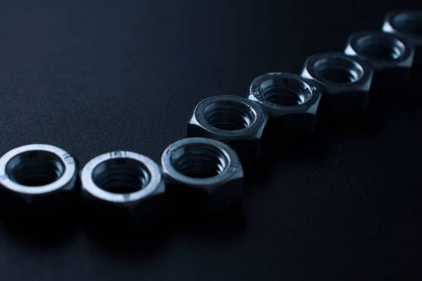 screw-nuts on a dark surface