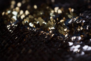 Altın ve gümüş pullu siyah kumaş.