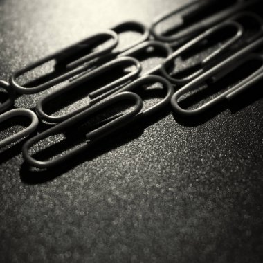  Metal bir yüzeyde siyah beyaz ataçlar var.