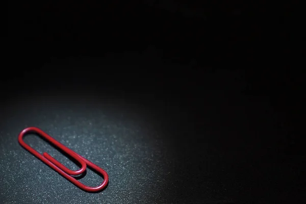 Rote Büroklammer Auf Einer Dunkelblauen Metalloberfläche Liegend — Stockfoto