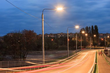 Şehrin varoşlarında küçük bir gece yolu. Fotoğraf uzun bir deklanşör hızında çekilmiştir..