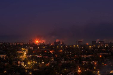 Dağlık bölgede fenerleri olan şehir. Gün batımı veya şafak vakti gökyüzü olan.