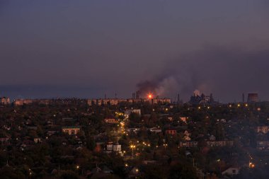 Dağlık bölgede fenerleri olan şehir. Gün batımı veya şafak vakti gökyüzü olan.
